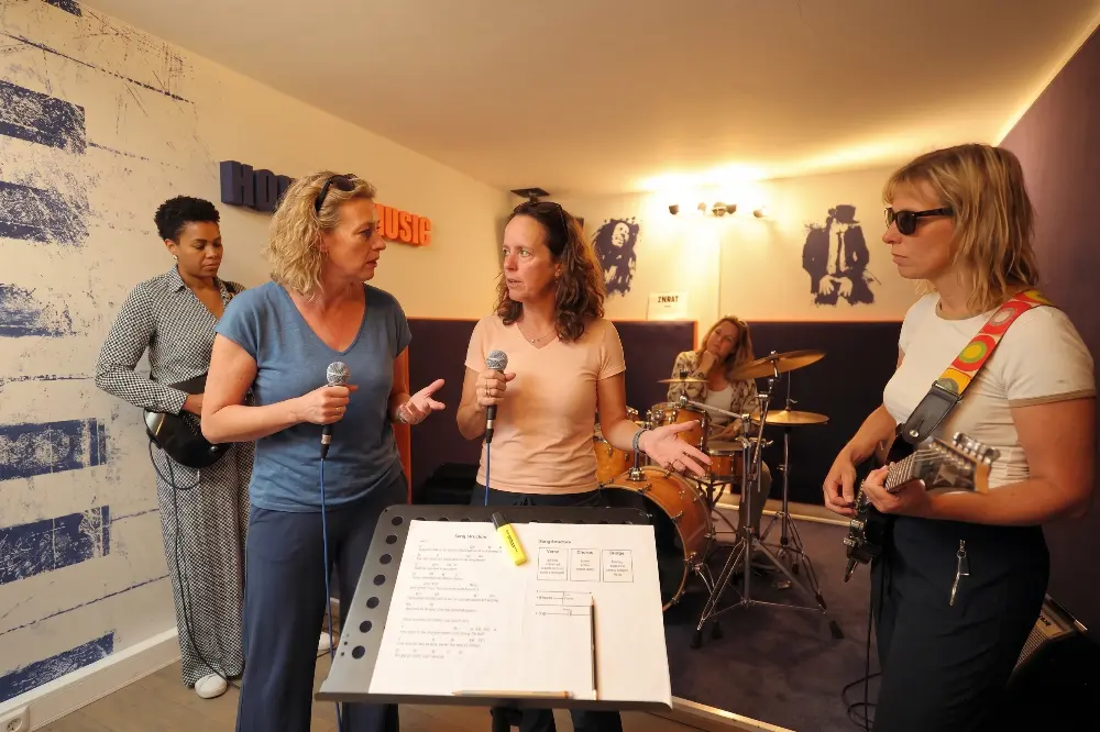 Deelnemers overleggen tijdens het zelfstandig repeteren, met het akkoordenblad op de standaard