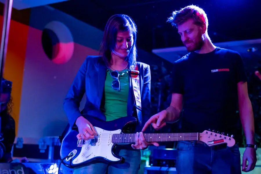 Deelnemer speelt een riff op een elektrische gitaar met versterker