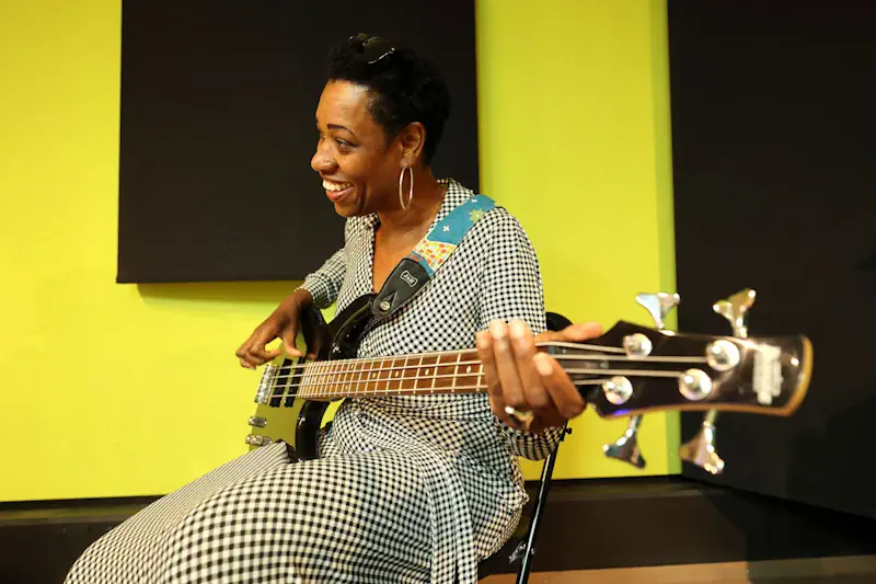 Deelnemer leert basgitaar bij muzikaal bedrijfsuitje